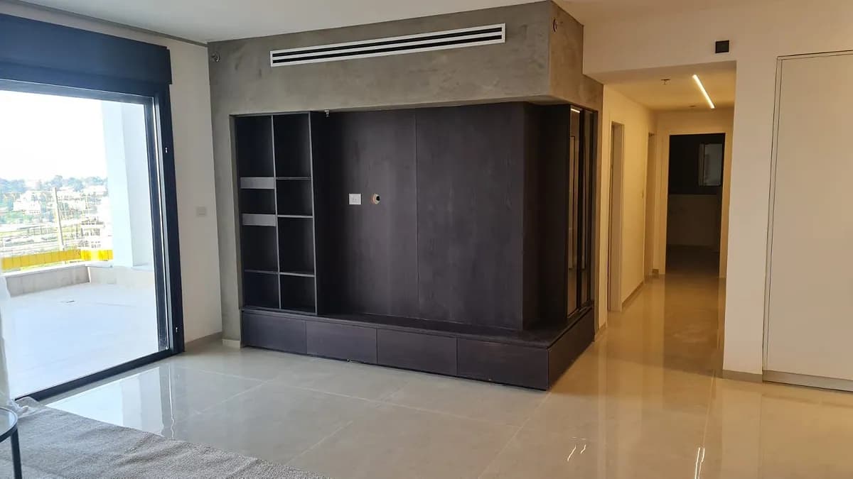 קיר טלוויזיה כהה בסלון עם מדפים צדדיים וחיפוי עליון