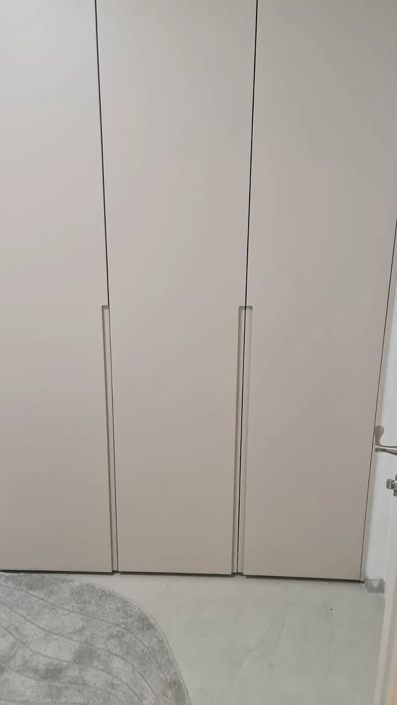 ארון בגדים גבוה בגוון בהיר עם ידיות ארוכות ורצפת שיש