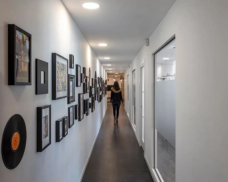 מסדרון ארוך עם קיר תמונות דקורטיבי ותאורה שקועה